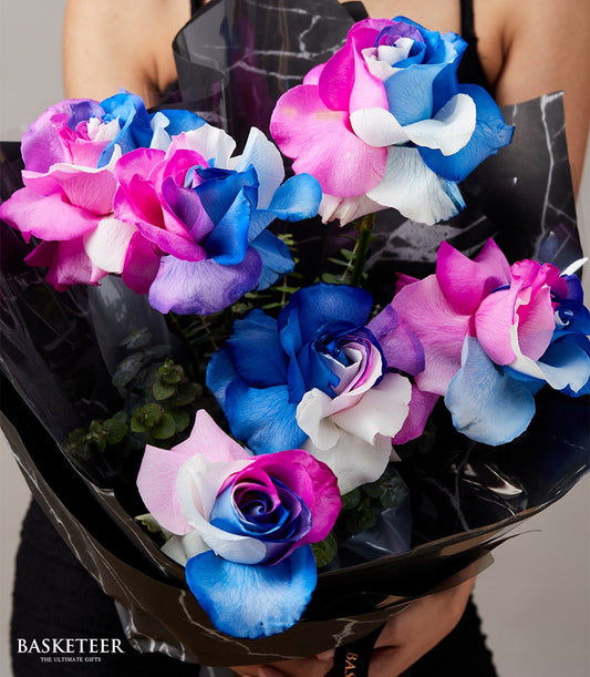 Vibrant rainbow roses bouquet with pink, blue, and white petals, wrapped in black paper for Valentine's Day