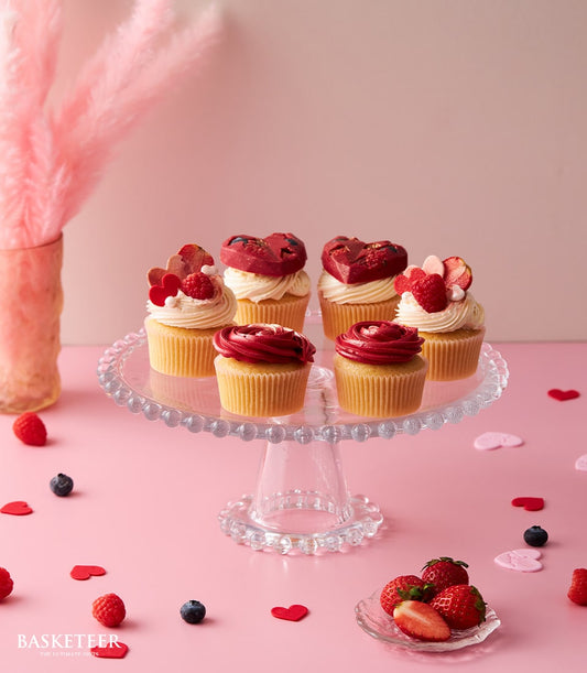 Fall In Love cupcake set with red heart chocolates and rose-shaped frosting on glass stand