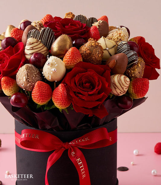 Red roses and chocolate-dipped strawberries in luxury black gift box for Valentine's Day