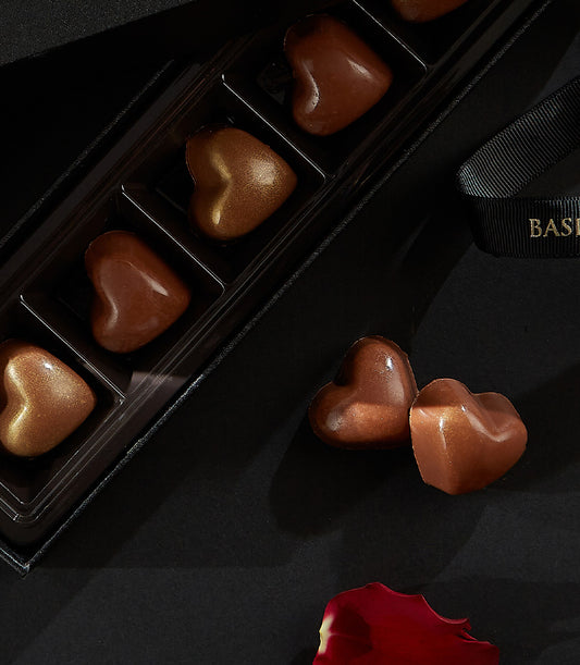 Charlotte Bakery artisan chocolate bonbons: Heart-shaped chocolates, some in a sleek black box, perfect for birthday cake delivery Bangkok.