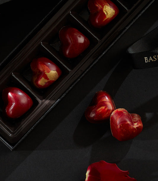 Luxury heart-shaped cherry liquor chocolates with gold marbling in black gift box, Valentine's Day premium confection