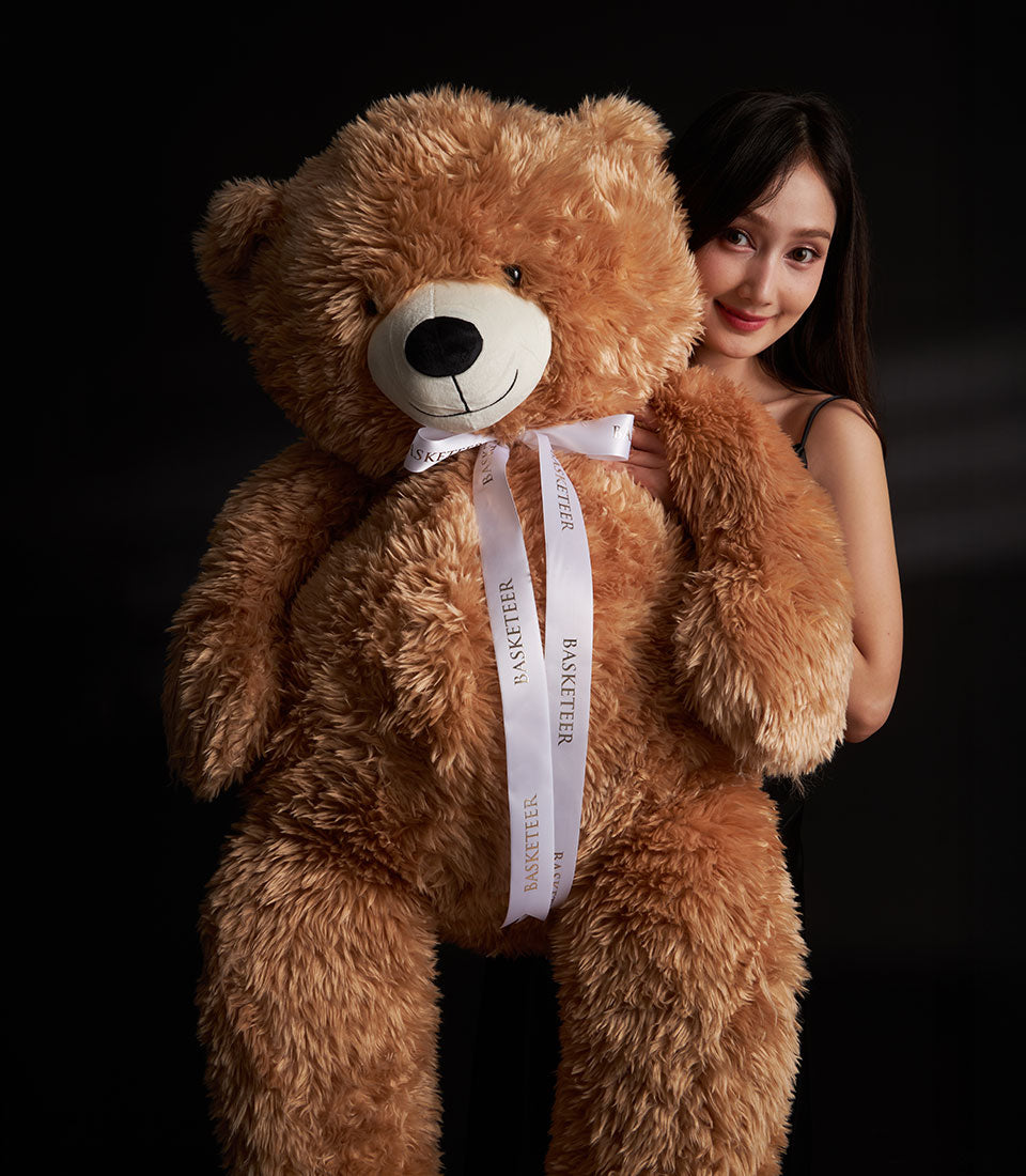 A luxurious Basketeer gift: a giant, soft brown teddy bear with white ribbon, perfect for Valentine's Day gift delivery in Bangkok.