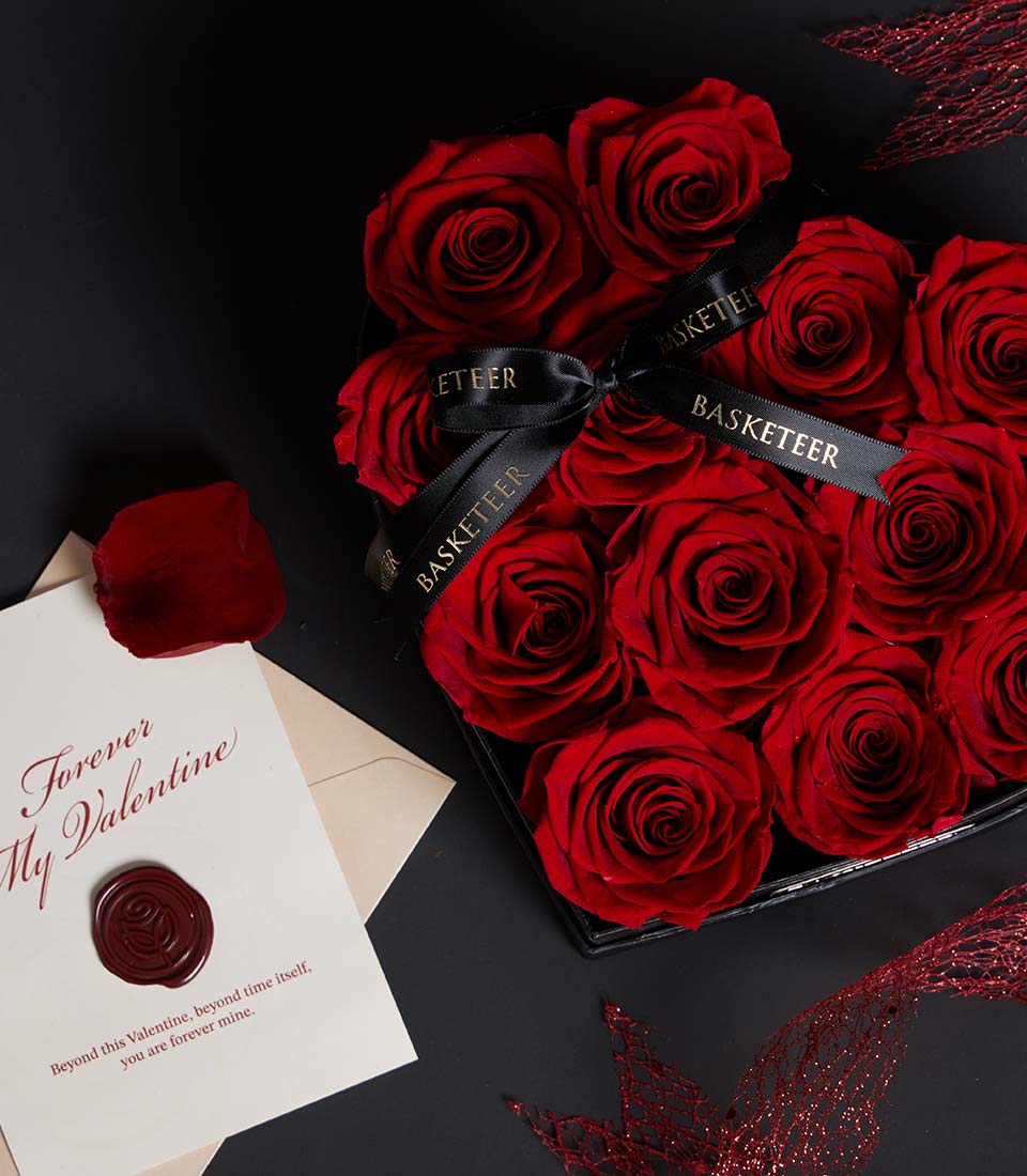 Deep red preserved roses in heart-shaped luxury box with gold-ribboned "Forever My Valentine" card