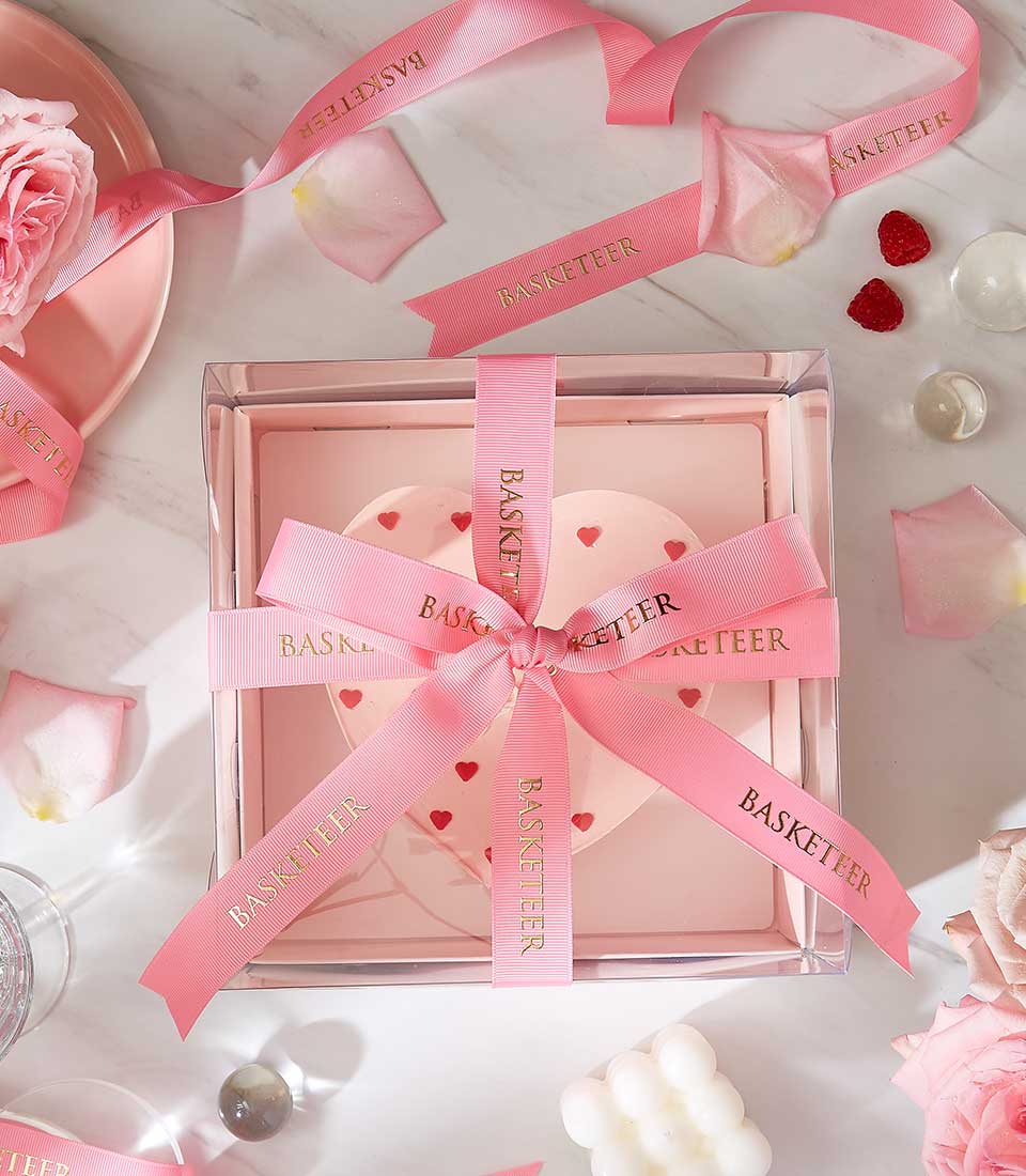 Heart-shaped love cake in pink gift box with rose petals and raspberries, Valentine's Day dessert