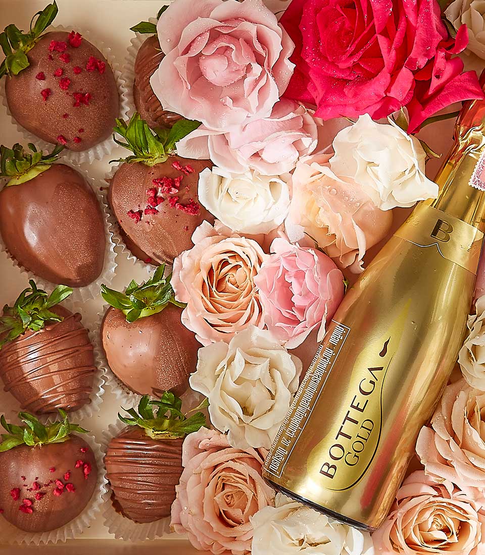 Luxury Valentine wine gift box with sparkling wine, chocolate-covered strawberries, and fresh pink roses