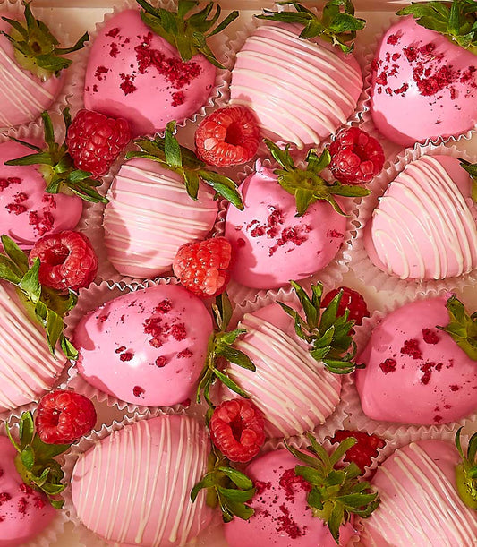 Deluxe pink chocolate-covered strawberries with white drizzle and raspberry pieces in gift box