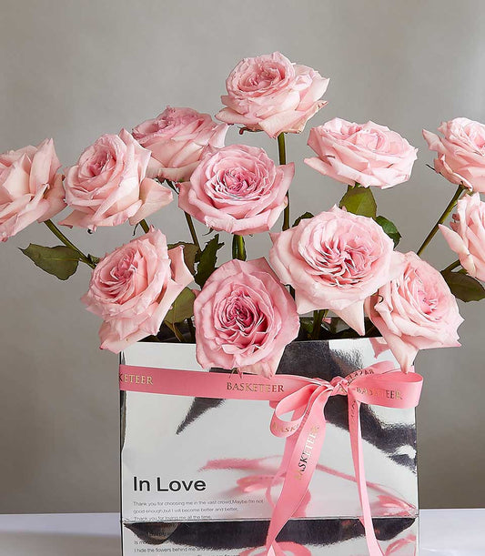 Light pink roses in silver gift box with pink satin ribbon, luxury flower gift for her