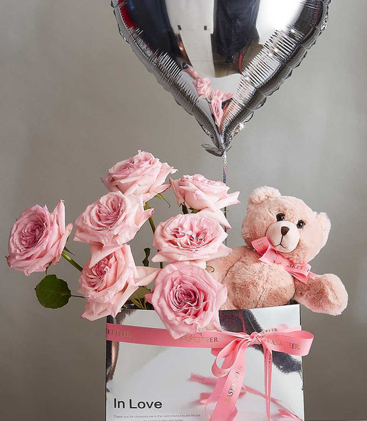 Pink roses with plush teddy bear and heart balloon in luxury Valentine's gift box