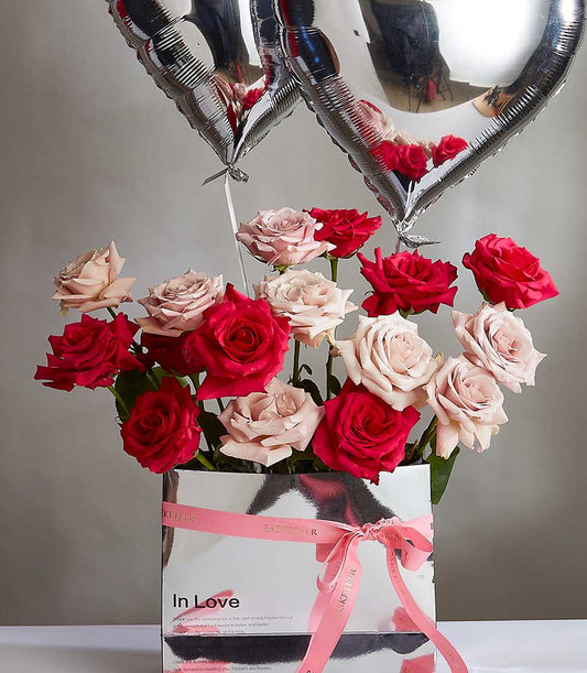 Fresh red and pink roses in silver box with heart balloons, Valentine's Day gift for her