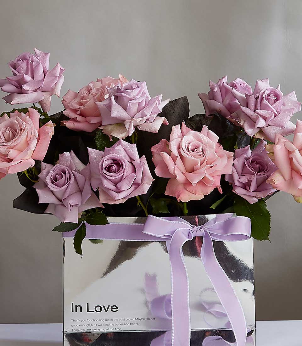 Soft pink and lavender roses in silver box with purple ribbon, fresh anniversary gift for her