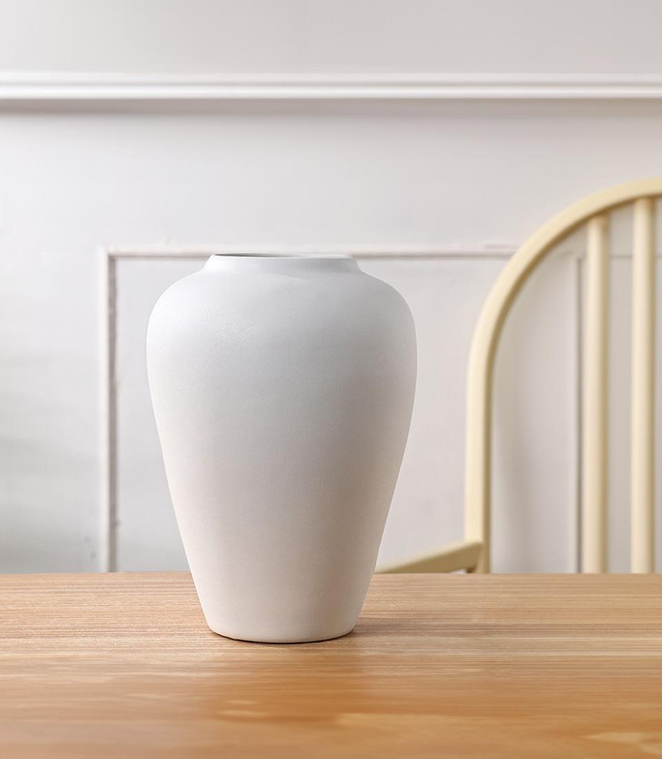 Minimalist white ceramic vase with matte finish and tapered rounded form for elegant home styling