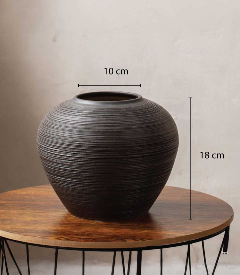 Dark textured ceramic vase with horizontal ridges and narrow opening for fresh flowers or home decor