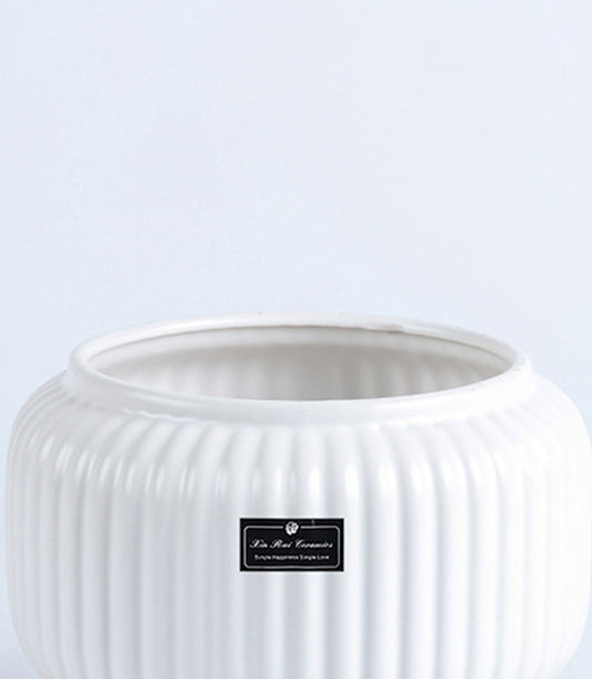 White ceramic fluted vase with ribbed texture, ideal for fresh flowers or decorative display