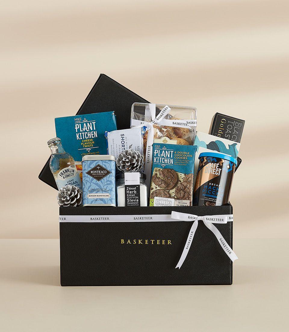 Black leather New Year gift hamper with gourmet snacks, artisan cookies, premium tonic water, and coffee inside
