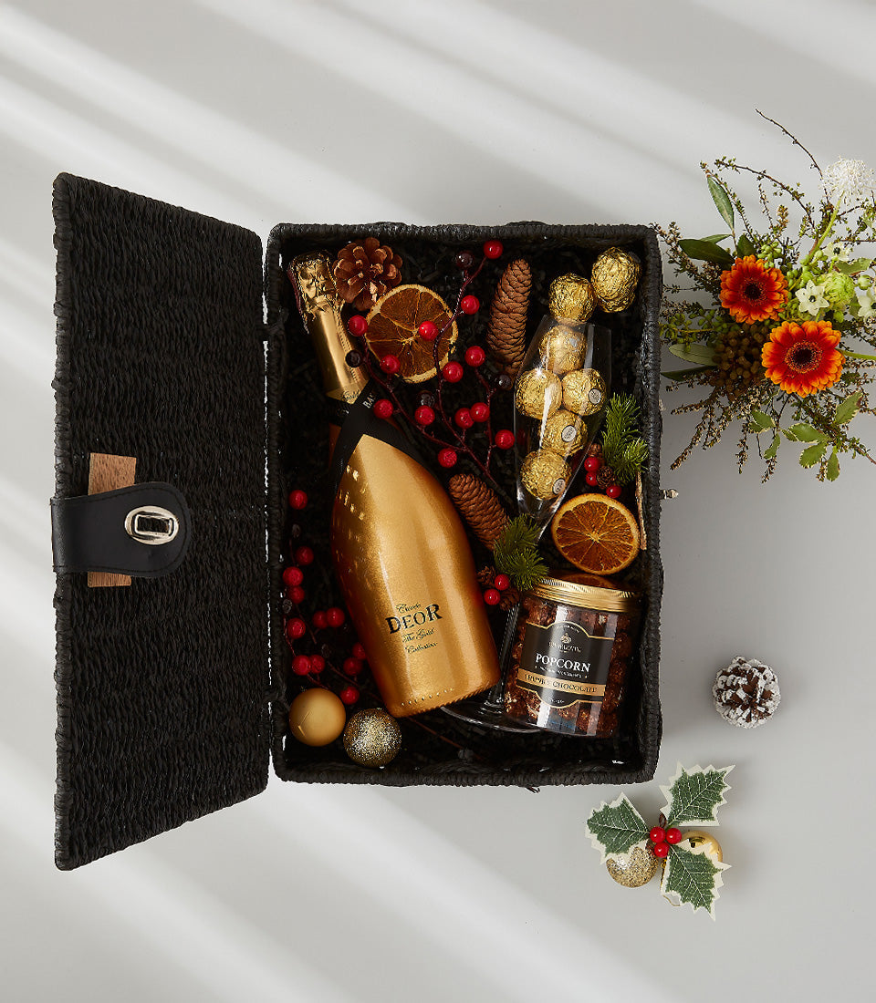 Deor Gold festive wine gift basket with champagne, chocolates, and holiday decor in black woven basket