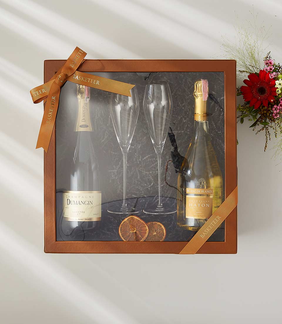 Classic double wine gift box with champagne bottles, flutes, and dried orange accents in luxury packaging