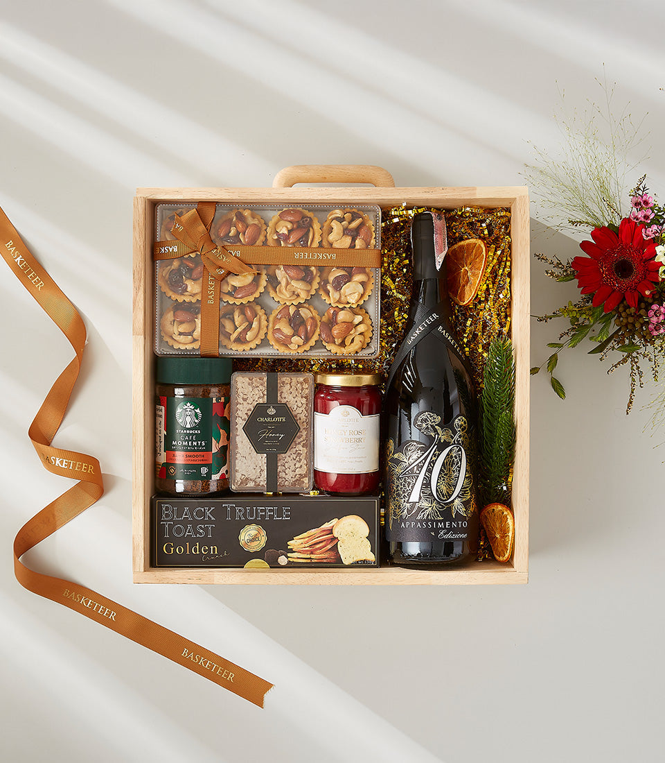 Premium red wine gourmet gift box with artisan tarts, truffle toast, and honey, tied with gold ribbon