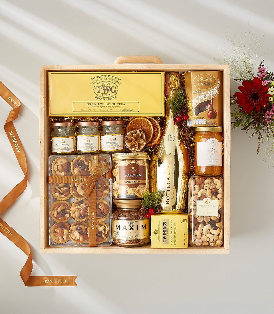 Luxury wine hamper in wooden crate with champagne, gourmet chocolates, tea, jam, and festive dried fruit garnish