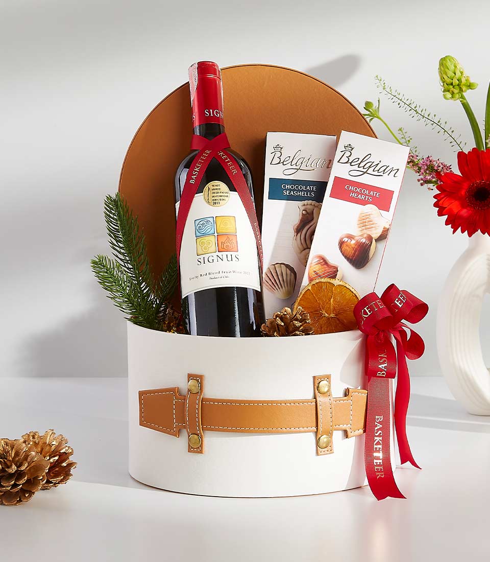 Classic red wine and Belgian chocolate gift basket with evergreen, dried citrus, and festive ribbon accents