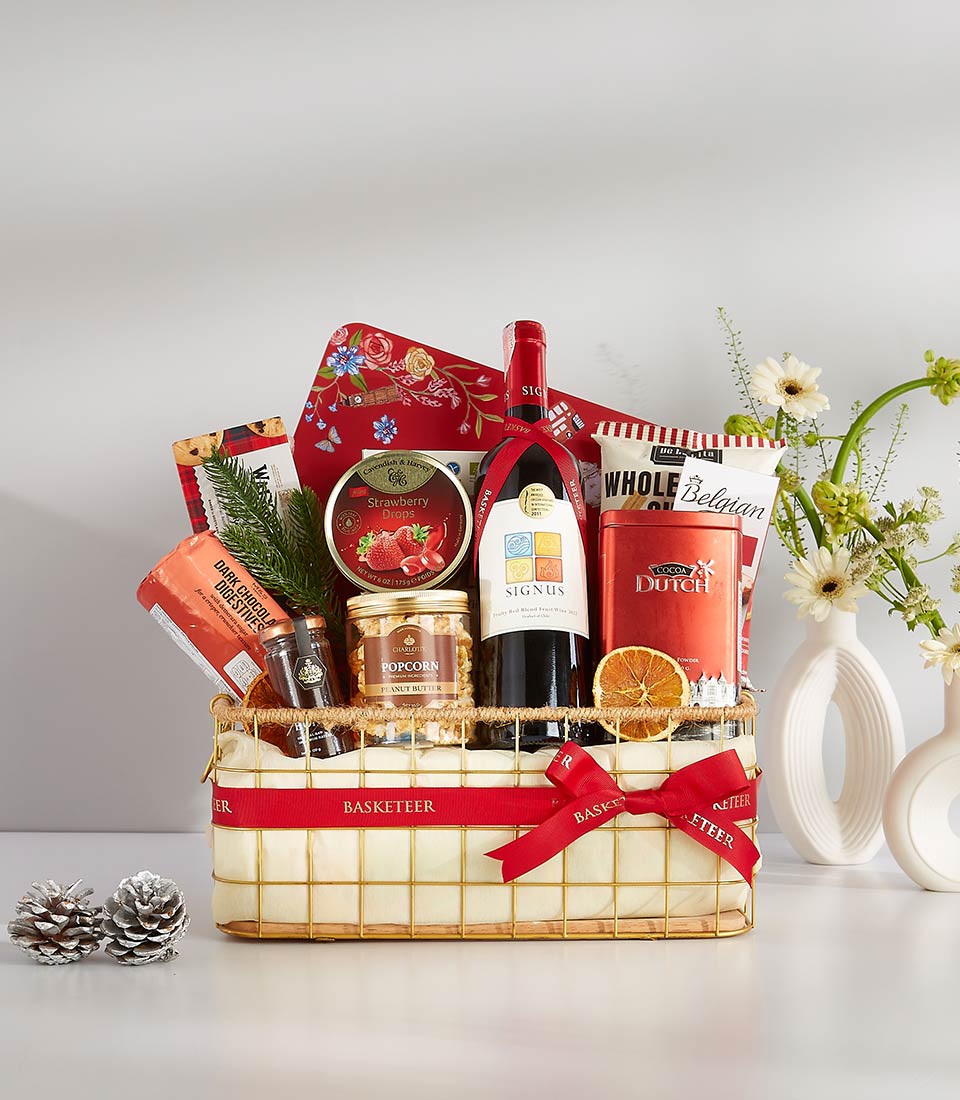 Red wine gourmet gift hamper with cocoa, chocolate, and artisan treats in gold wire basket