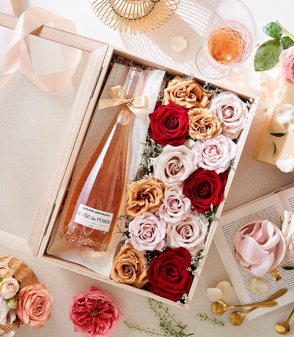 Rosé wine and preserved roses gift box in deep red, blush pink, and peach tones for anniversaries
