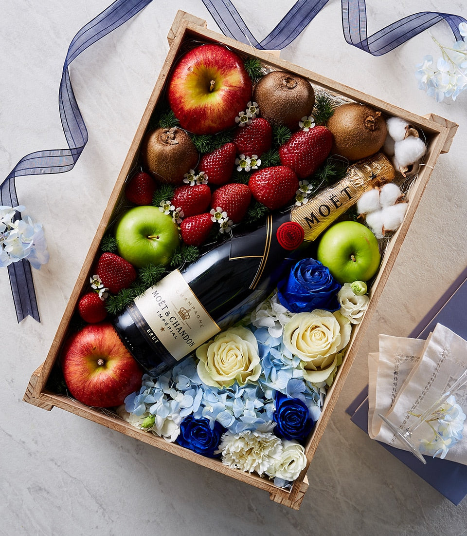 Deluxe wooden gift box with champagne, fresh mixed fruits, and premium blue and white flower arrangement