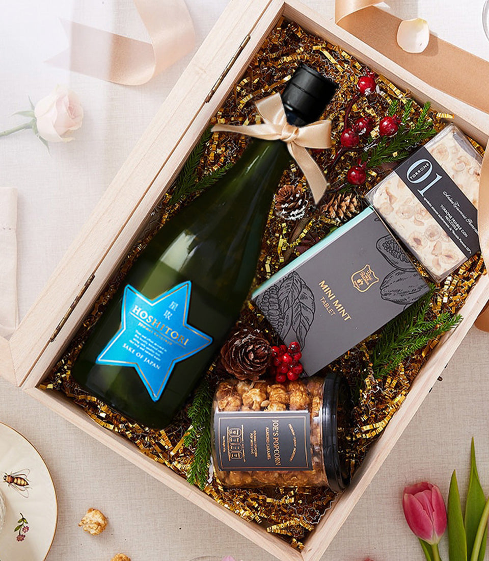 Luxury Japanese sparkling wine with artisan chocolates and gourmet treats in wooden gift box