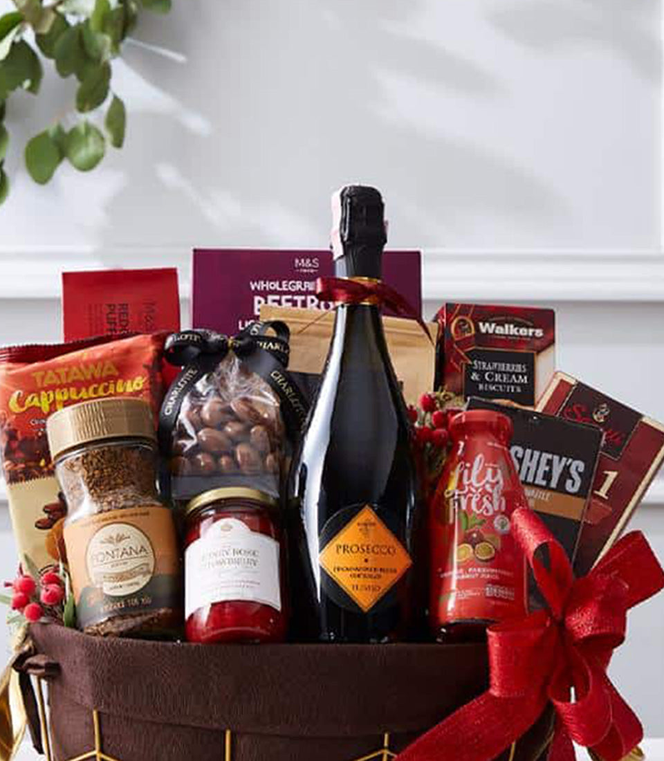 Prosecco celebration gift basket with gourmet treats, red satin bow, and festive berry garnish