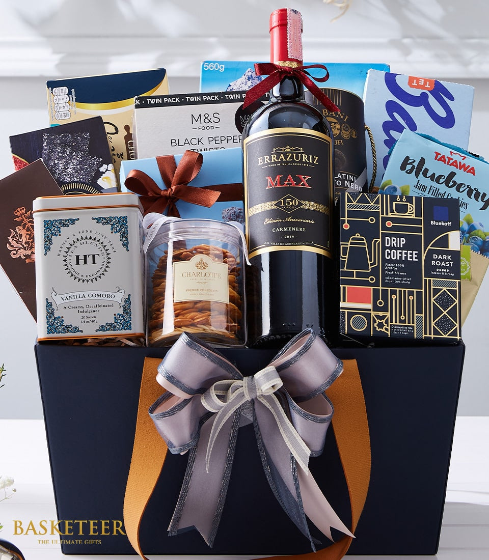 Luxe wine gift basket with red wine, gourmet cookies, premium tea, and artisan coffee in dark blue presentation box