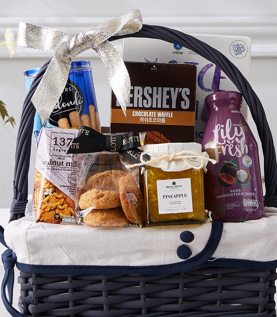 Dark grey woven gift basket with gourmet treats, chocolate waffle, mangosteen juice, and pineapple jam for New Year gifting