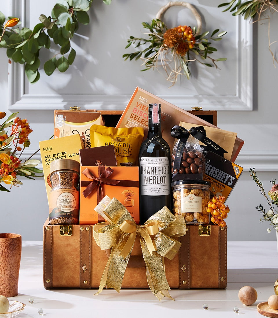 Luxurious brown leather trunk filled with Merlot wine, gourmet coffee, biscuits, and chocolate treats with gold bow