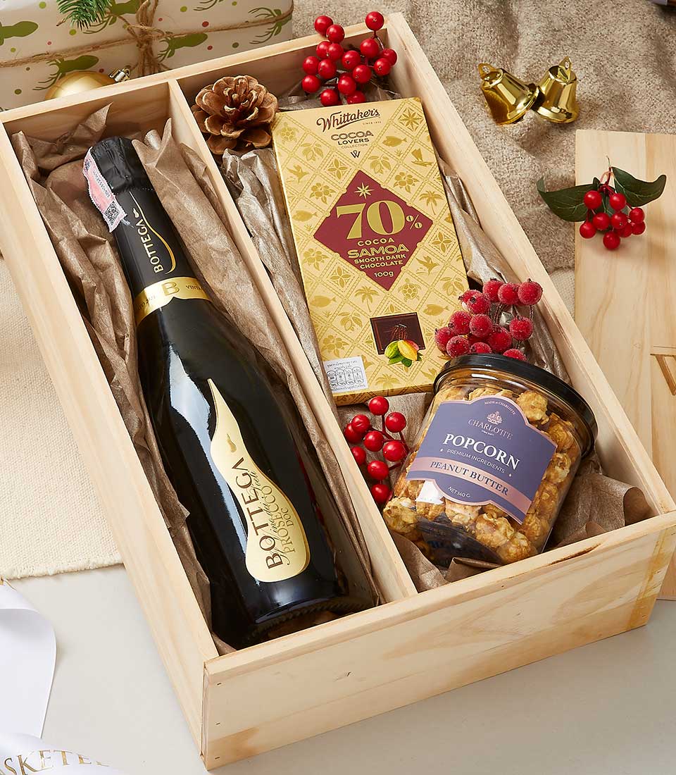 Luxury wine and chocolate gift box with sparkling wine, artisan chocolate, and gourmet popcorn in wooden compartments