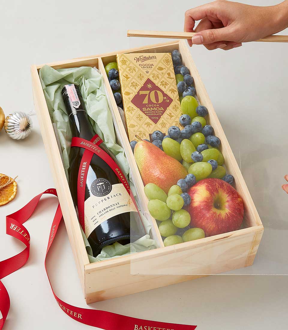 Premium wooden wine crate with white wine, fresh grapes, berries, pear, apple, and dark chocolate bar