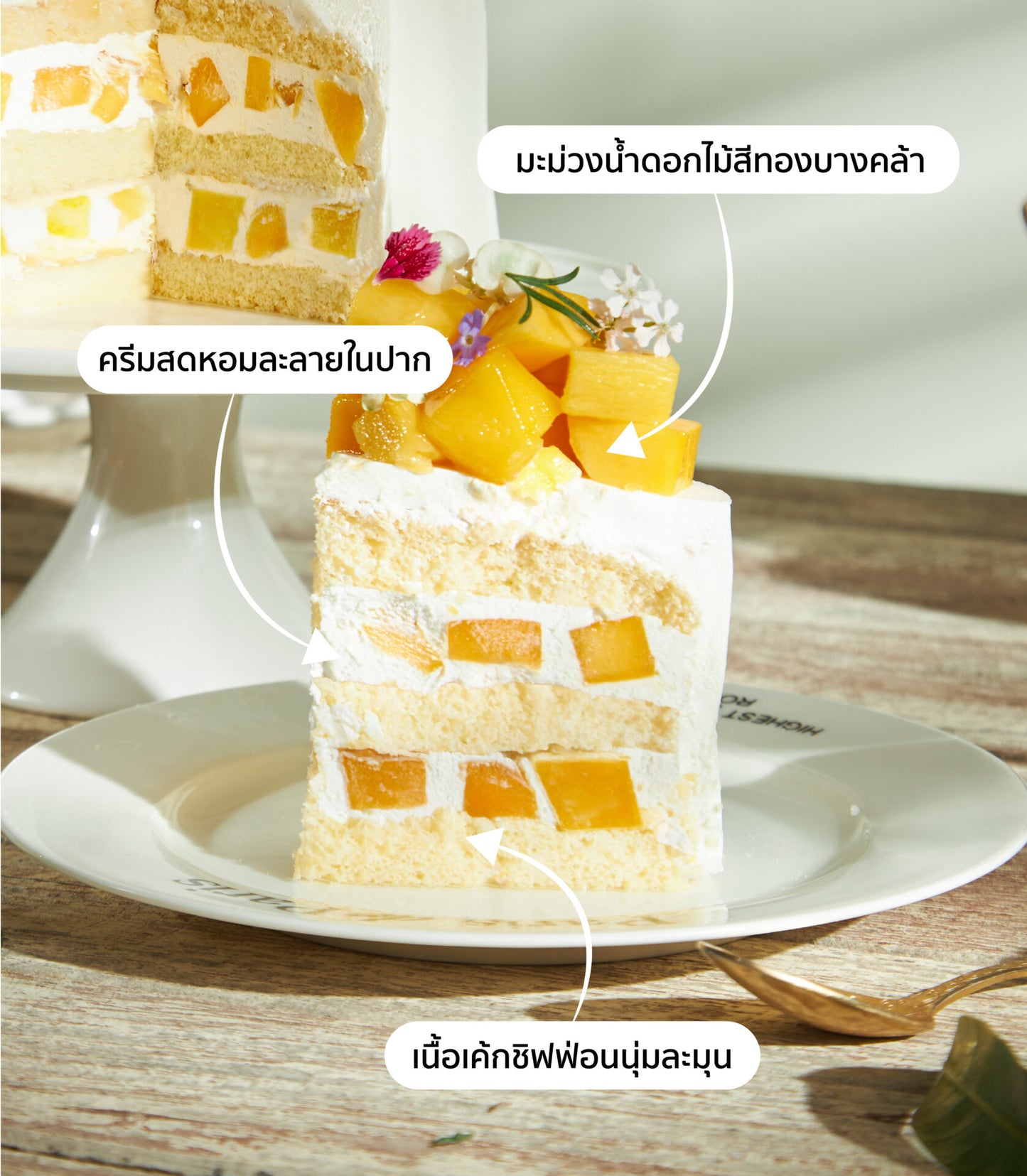 Mango chiffon cake slice with fresh cream, diced mango, and edible flowers on ceramic plate