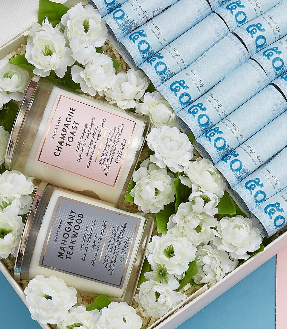 Luxury Mother's Day gift box with champagne toast and mahogany teakwood candles, white flowers, and currency gift