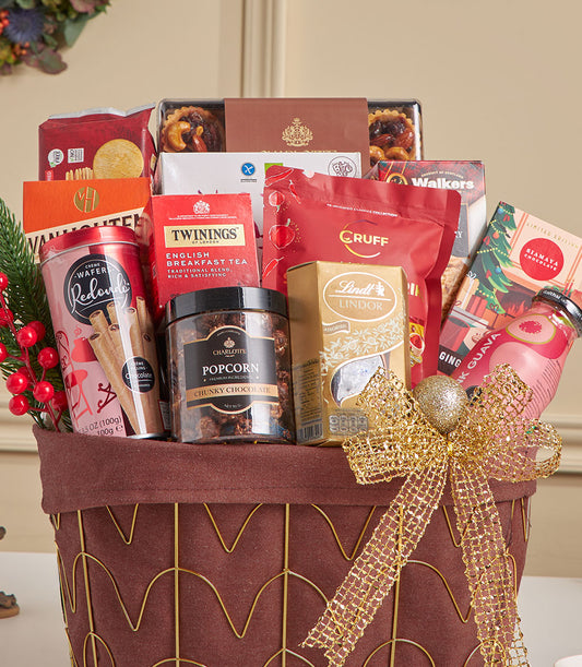 Festive gold-framed gift hamper with red fabric liner, gourmet chocolates, teas, and holiday treats for New Year celebrations