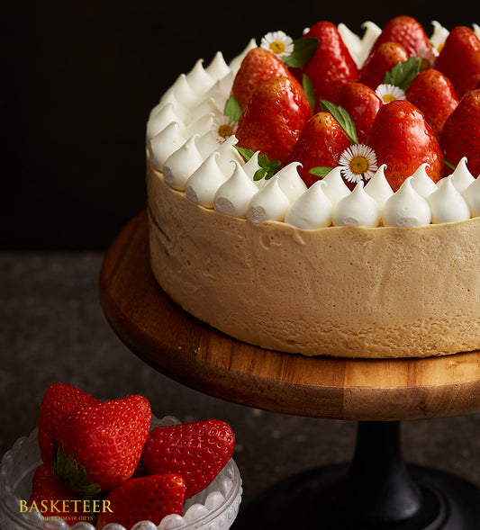 Strawberry swirl vanilla mousse cake with meringue peaks and fresh berries on wooden stand