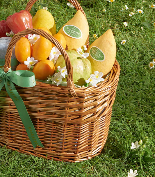 Golden Harvest mango gift basket with fresh Nam Doc Mai fruit, roses, and white flowers on wicker