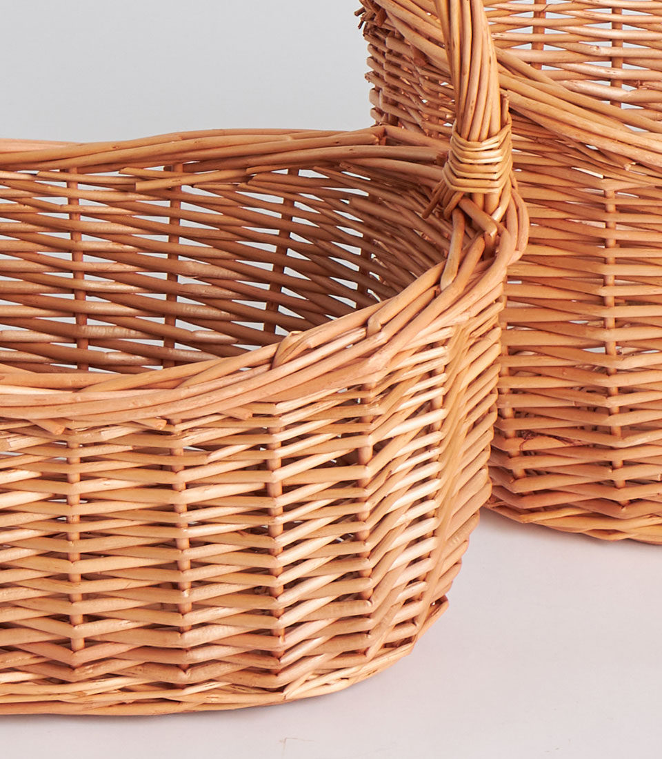 Handwoven light brown wicker baskets with natural fibre weave and tall wrapped handles, perfect for luxury gift hampers