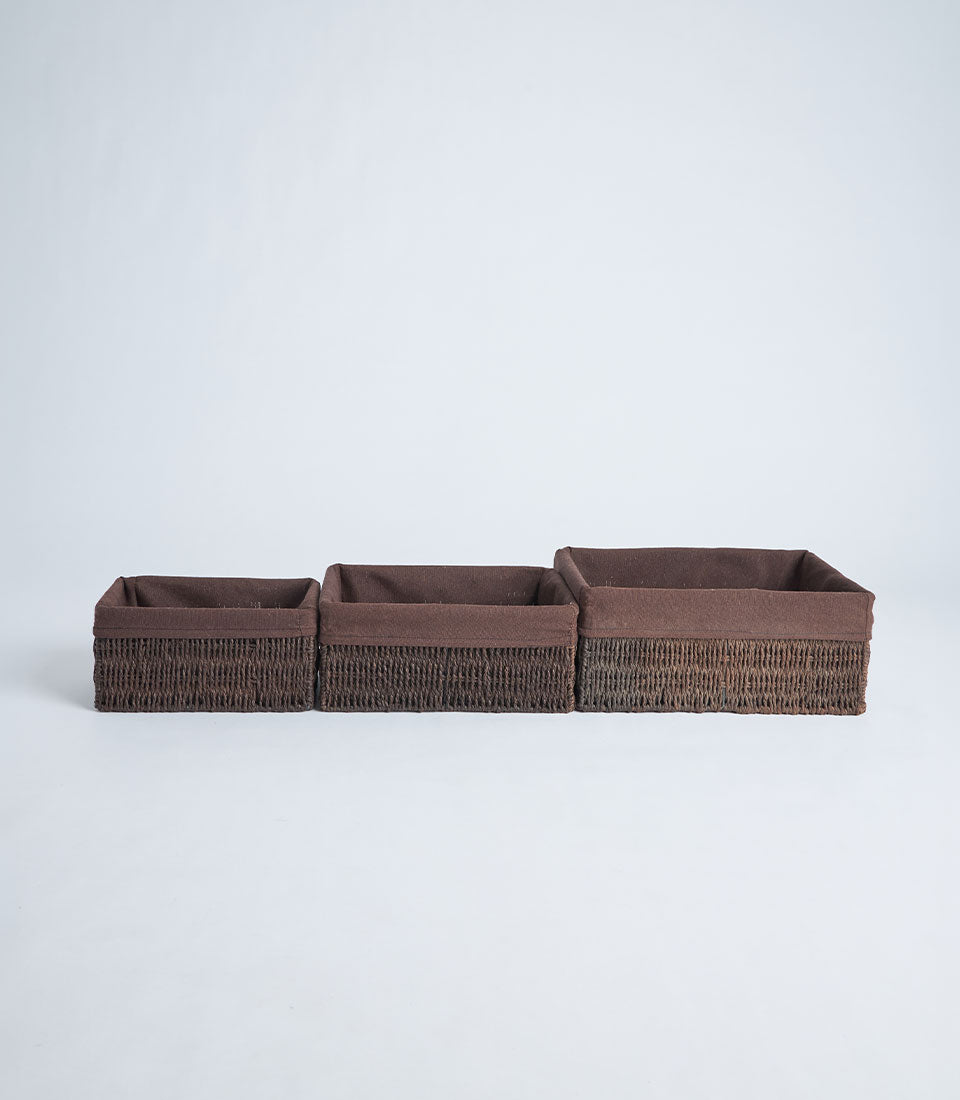 Handwoven dark brown wicker storage baskets with fabric linings in graduated sizes