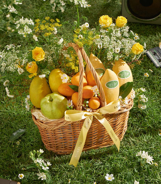 Luxury fruit basket with Nam Doc Mai mangoes, guava, and fresh yellow roses on wicker