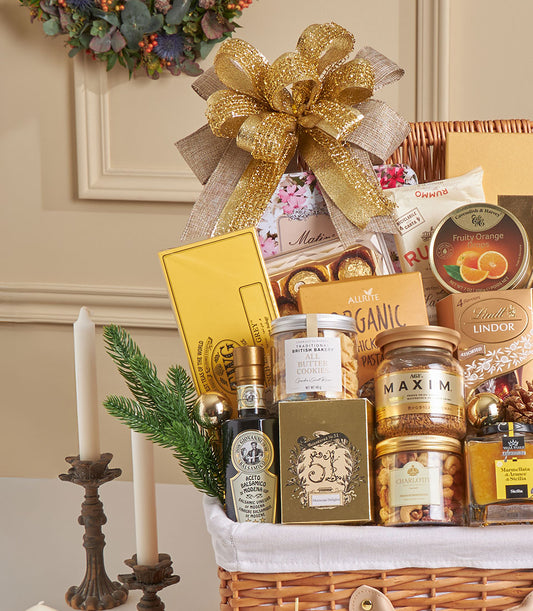 Luxury wicker gift hamper filled with gourmet chocolates, truffles, and fine foods with gold bow, ideal for New Year