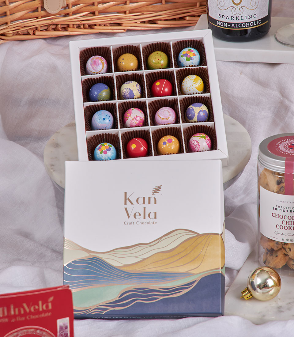 Champagne-style luxury chocolate gift box with colorful artisan truffles, cookies, and sparkling beverage for New Year