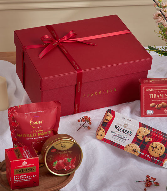 Red velvet gourmet gift basket with premium treats, paprika chips, strawberry candies, tea, tiramisu chocolate, and