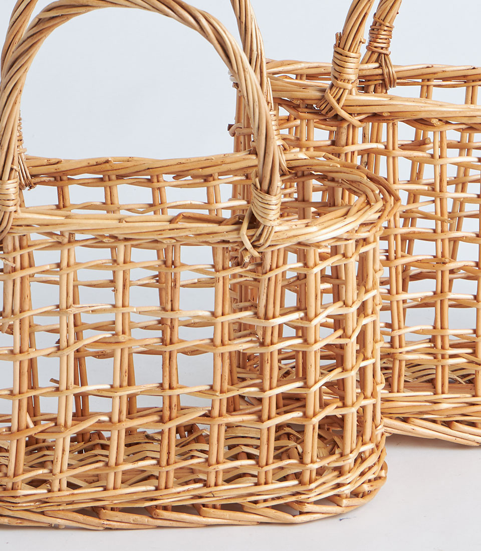 Handwoven light brown wicker baskets with open-weave design and arched willow handles