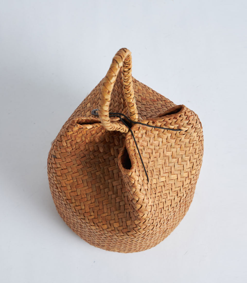 Natural straw gift basket with woven rope handle and red tassel closure