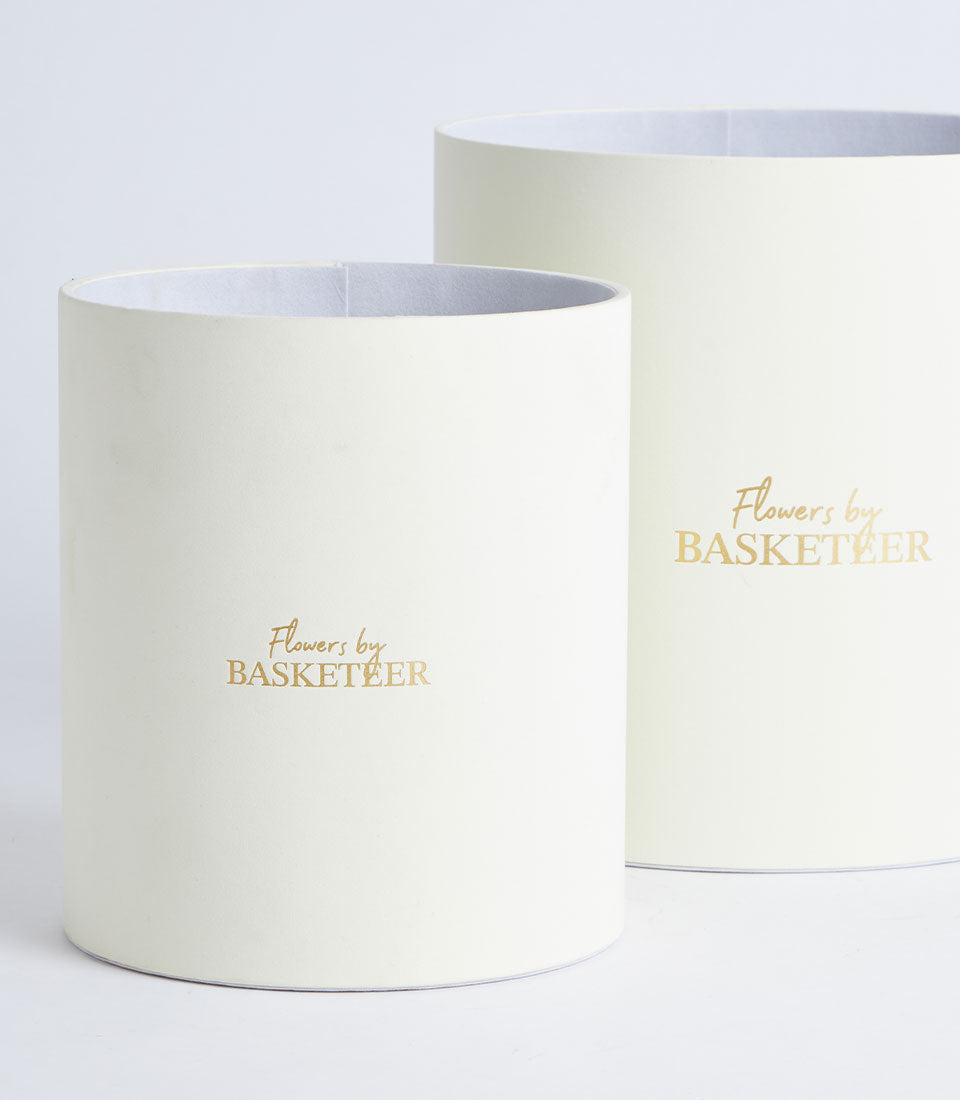 Two elegant Basketeer ivory round gift boxes, one larger and one smaller, featuring