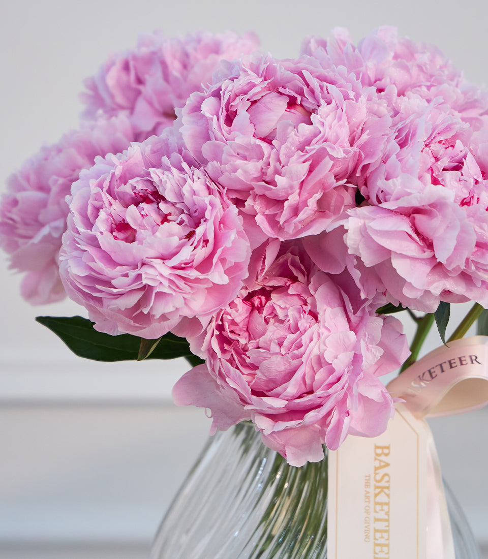 A luxurious vase arrangement from Flowers by Basketeer featuring vibrant pink peonies