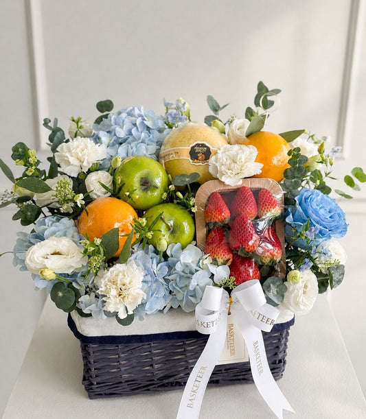 Basketeer luxury fruit and floral hamper in a dark woven wicker basket,