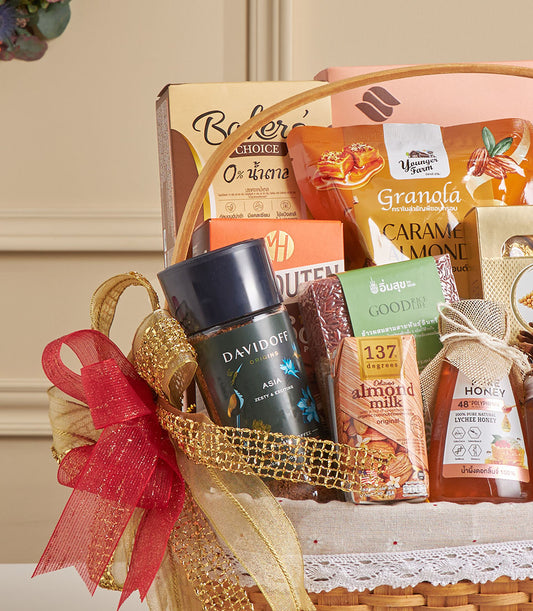 Premium gourmet hamper with almond milk, lychee honey, granola and coffee in ribbon-tied gift basket for New Year